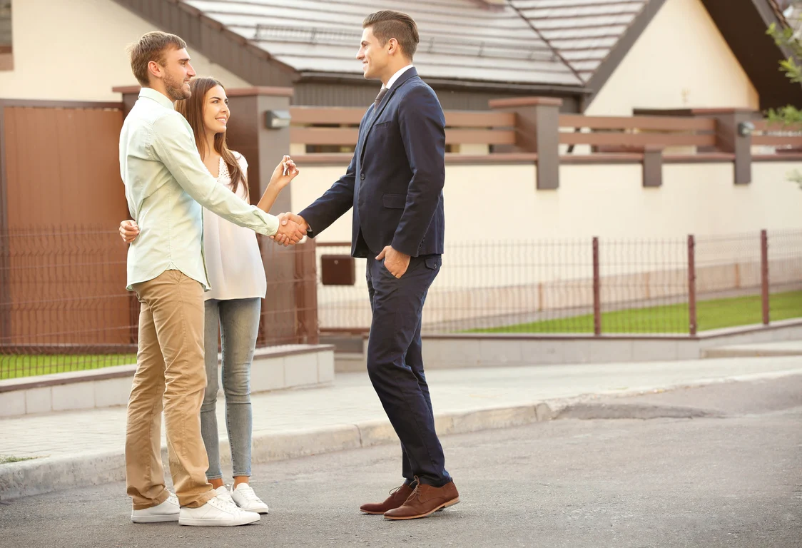 Young Couple with Real Estate Agent near House